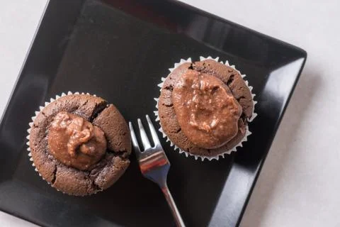Flat lay above chocolate cup cake muffin on the black square plate Stock Photos