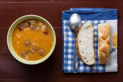 Flat lay above cooked beans with sausages and bread on the kitch Stock Photos