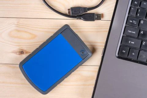 Flat lay above external hard disc by lap top computer on the wooden table Foto stock
