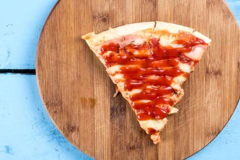 Flat lay above fresh baked pizza triangle slice on the wooden board with cutt Stock Photos