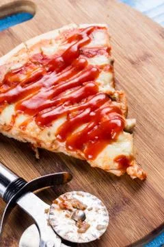 Flat lay above fresh baked pizza triangle slice on the wooden board with cutt Stock Photos