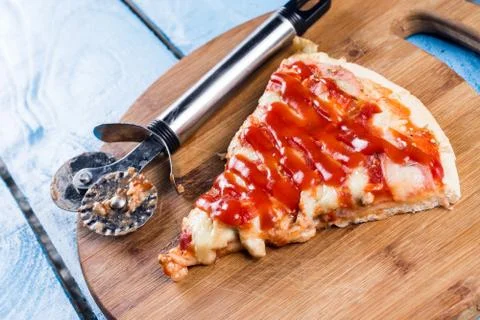 Flat lay above fresh baked pizza triangle slice on the wooden board with cutt Stock Photos