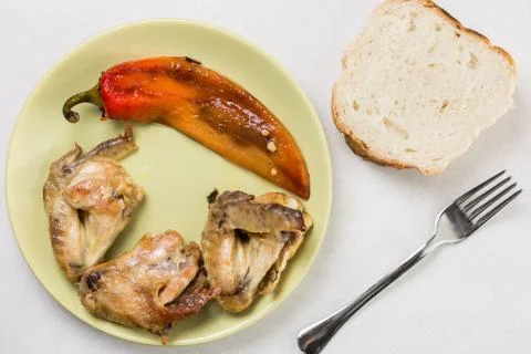 Flat lay above fried chicken wings with fried paprika served on the plate wit Stock Photos