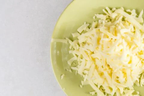 Flat lay above grated cheese on the plate with copy space above white marble Stock Photos