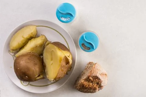 Flat lay above served cooked potatoes with salt and pepper above white marble Foto stock