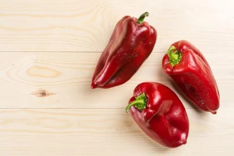 Flat lay above three fresh red paprika with copy space Stock Photos