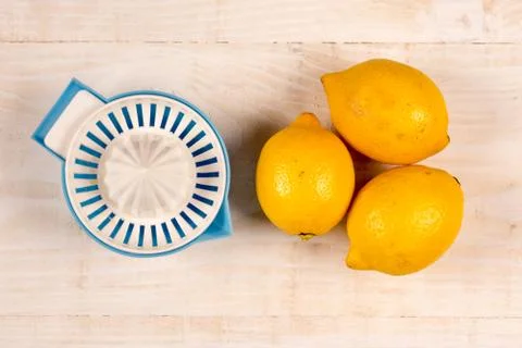 Flat lay above three lemons and plastic strainer Stock Photos