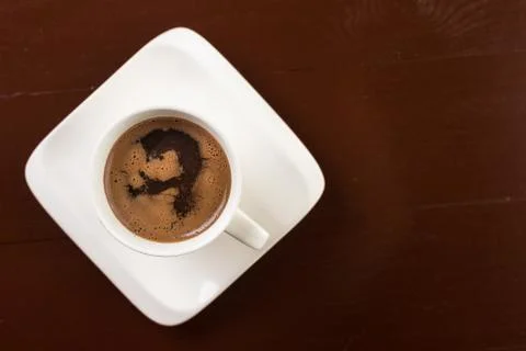 Flat lay above white cup of coffee on the brown wooden table with copy space Stock Photos