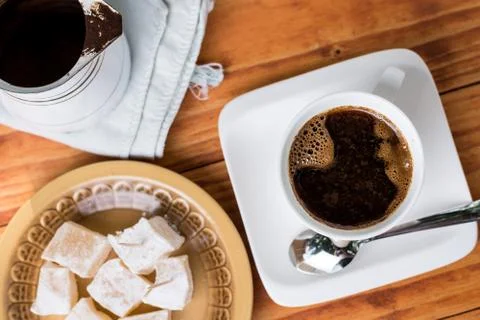 Flat lay above white cup of coffee and turkish delight on the plate Stock Photos