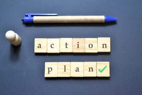 Flat lay with action plan tiles, pen, and wooden pawn on dark surface symbo.. Foto stock
