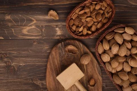 Flat lay of almonds in the wicker plates with other accessories on brown wood Stock Photos