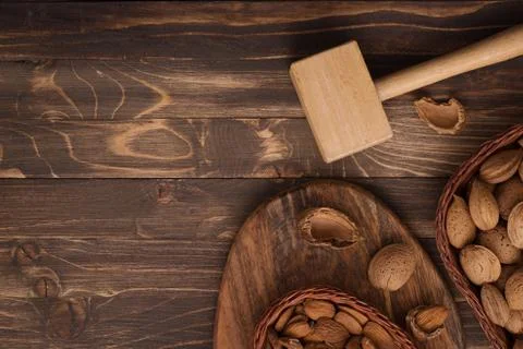 Flat lay of almonds in the wicker plates with other accessories on brown wood Stock Photos