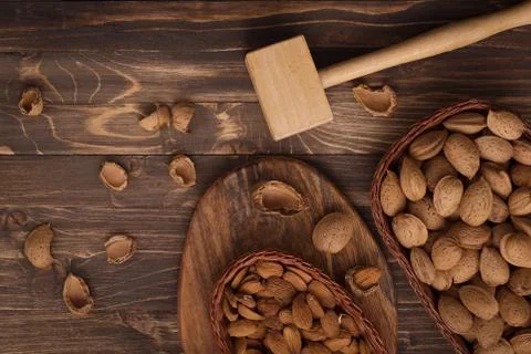 Flat lay of almonds in the wicker plates with other accessories on brown wood Stock Photos