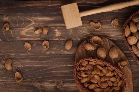 Flat lay of almonds in the wicker plates with other accessories on brown wood Stock Photos