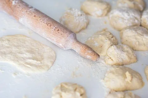 Flat lay angle view of a kitchen desk with flour, dough and roller. Photos