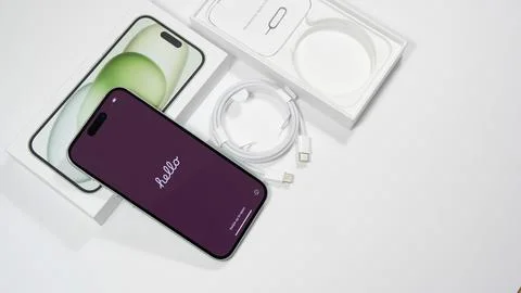 Flat lay Apple iPhone 15 with Hello text welcome screen. Brand new iPhone in new Stock Photos