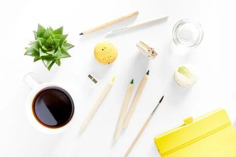 Flat lay art tools with macaroons, coffee, succulent, notepad on white Stock Photos