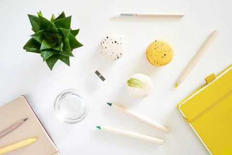 Flat lay art tools with macaroons, coffee, succulent, notepad on white Stock Photos