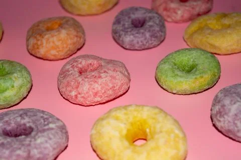 Flat lay of assorted-color sweet donuts that look delicious on a pink backg.. Stock Photos