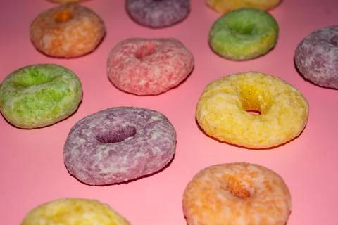 Flat lay of assorted-color sweet donuts that look delicious on a pink backg.. Stock Photos
