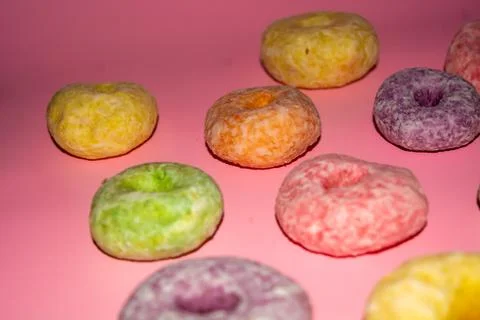 Flat lay of assorted-color sweet donuts that look delicious on a pink backg.. Stock Photos
