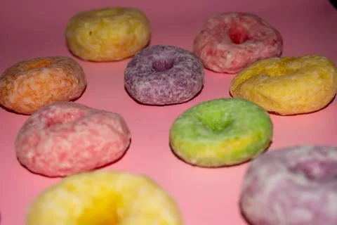 Flat lay of assorted-color sweet donuts that look delicious on a pink backg.. Stock Photos