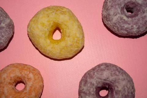 Flat lay of assorted-color sweet donuts that look delicious on a pink backg.. Stock Photos
