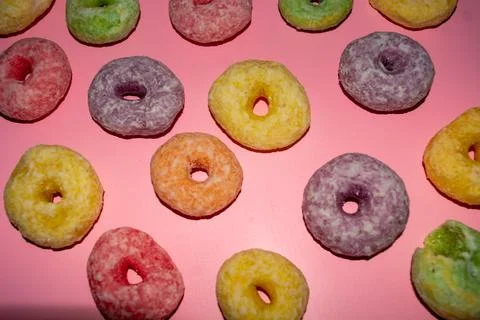 Flat lay of assorted-color sweet donuts that look delicious on a pink backg.. Stock Photos