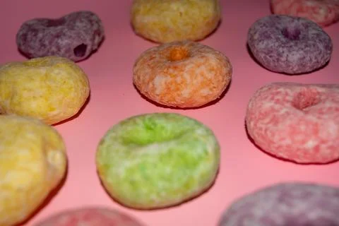 Flat lay of assorted-color sweet donuts that look delicious on a pink backg.. Stock Photos