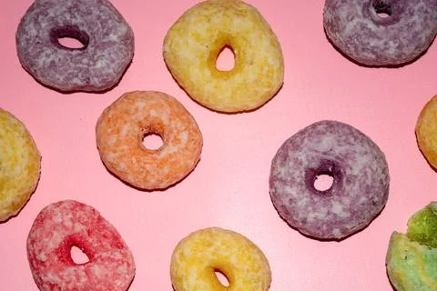 Flat lay of assorted-color sweet donuts that look delicious on a pink backg.. Stock Photos