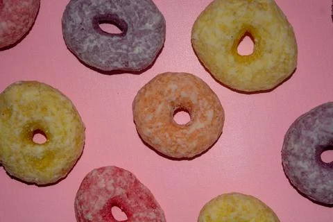 Flat lay of assorted-color sweet donuts that look delicious on a pink backg.. Stock Photos