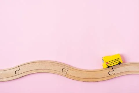 Flat lay back to school composition with yellow school bus model and wooden r Stock Photos