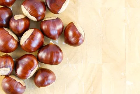 Flat-lay background image of fresh sweet chestnuts on a wooden background Stock Photos