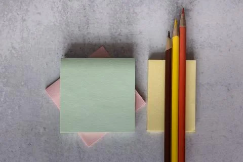 Flat lay background of stacked square note pads and pencils Stock Photos