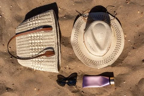 Flat Lay of Beach Essentials Woven Straw Bag Hat Sunglasses and Cream Tube .. Stock Photos