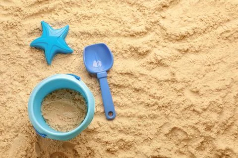 Flat lay of beach toy kit on sand, space for text. Outdoor play 写真素材