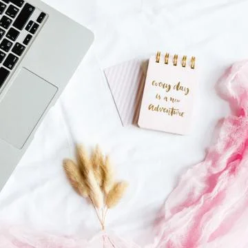 Flat lay bed workspace with laptop, notebook, dry flowers on white background Foto stock