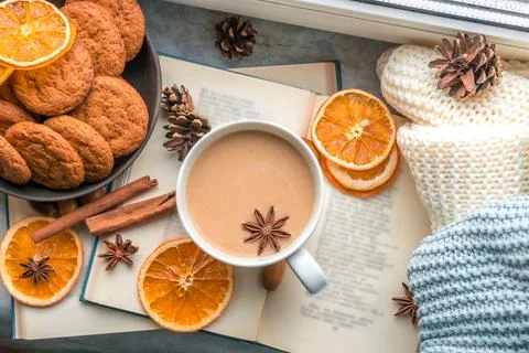 Flat lay with big cup of coffee, book and knitted blankets by the window Stock Photos