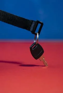 Flat Lay Black Keychain with Key on Red and Blue Background Stock Photos