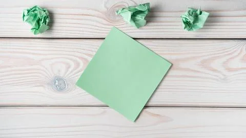 Flat lay of blank empty green sticker sticky note near crumpled notes on grey Stock Photos
