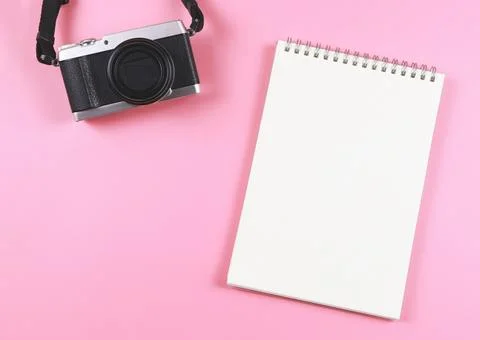 Flat lay of blank page opened notebook and camera on pink  background with .. Stock Photos