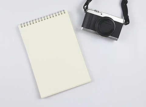 Flat lay of blank page opened notebook and camera on white  background with.. Stock Photos