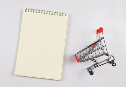Flat lay of  blank page opened notebook and shopping trolley or shopping ca.. Stock Photos