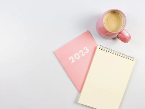 Flat lay of blank paper note book on pink diary 2023 and pink cup of coffee.. Stock Photos
