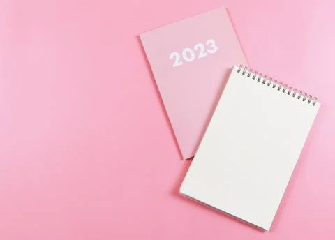 Flat lay of blank paper note book on pink diary 2023 on pink  background. Stock Photos