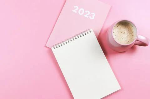 Flat lay of blank paper note book on pink diary 2023 and pink cup of coffee.. Stock Photos