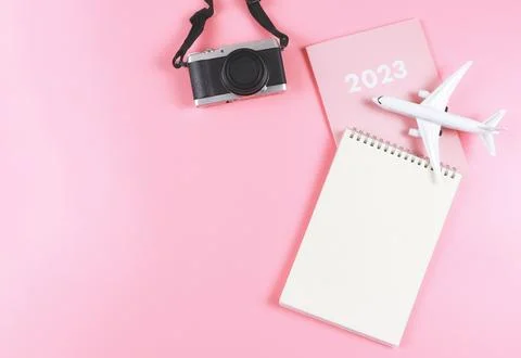 Flat lay of blank paper note book on pink diary 2023 with  airplane model  .. Stock Photos