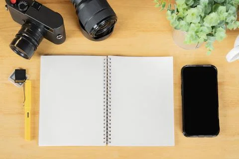 Flat lay of blank paper notebook with camera, memory cards, lens and phone .. Stock Photos
