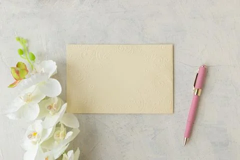 Flat lay with blank textured sheet with pink pen and white orchid on white co Stock Photos