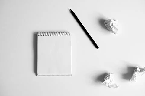 Flat lay of blank white notepad, pencil and crumpled paper on white backgroun Stock Photos